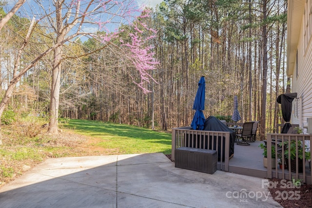 7025 Ridgeway Rd, Stanley, NC 28164 - view of patio featuring a wooden deck, outdoor dining area, and a view of trees
