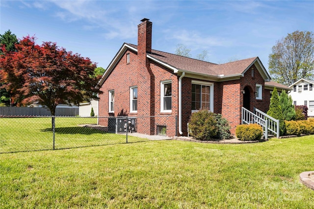 view of side of home with a chimney, fence, roof with shingles, a lawn, and brick siding