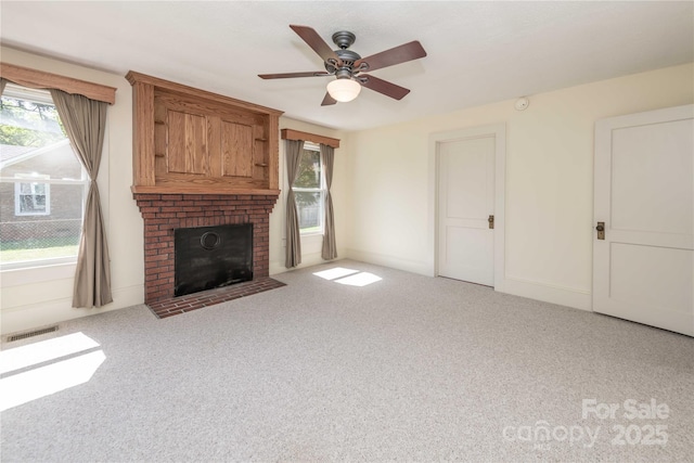 unfurnished living room with a healthy amount of sunlight, carpet flooring, visible vents, and a fireplace