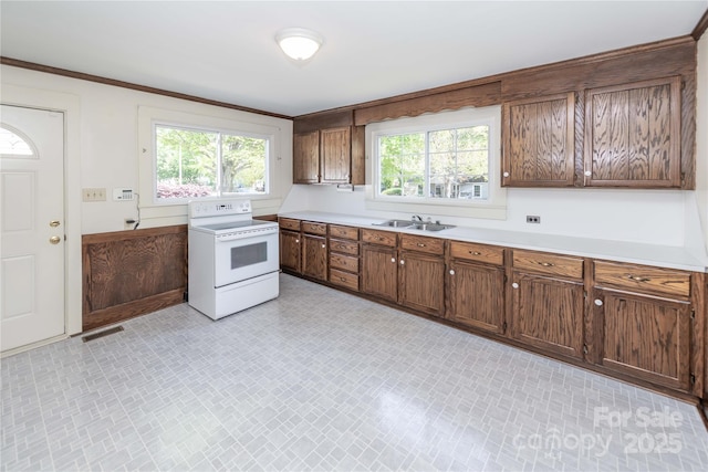 kitchen with white electric stove, plenty of natural light, light countertops, and visible vents