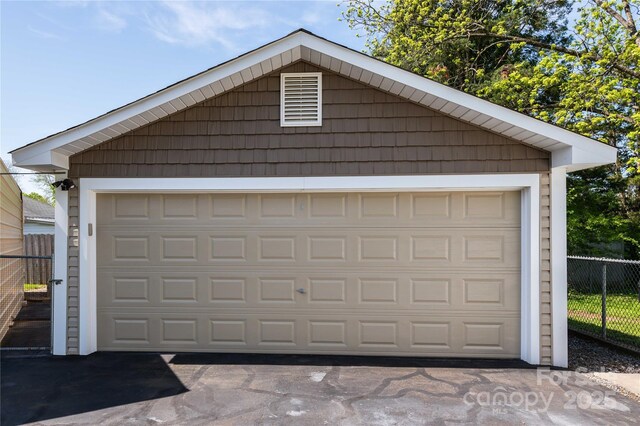 detached garage featuring fence