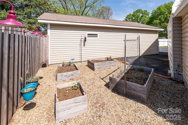exterior space featuring a garden and fence