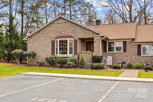 ranch-style home with brick siding, crawl space, uncovered parking, and a chimney