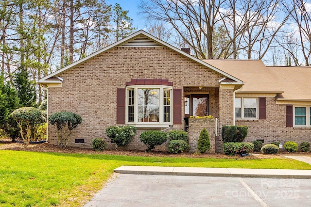 view of front of home featuring brick siding, crawl space, and a front yard
