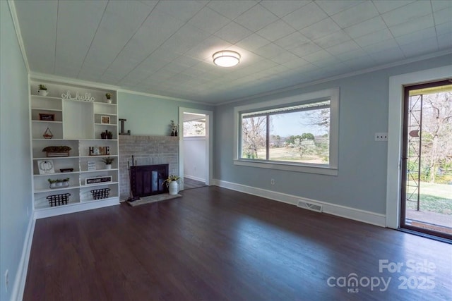 unfurnished living room featuring dark wood-style floors, a fireplace with raised hearth, baseboards, and ornamental molding