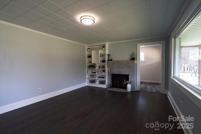 unfurnished living room with dark wood-style flooring, a fireplace, baseboards, and ornamental molding