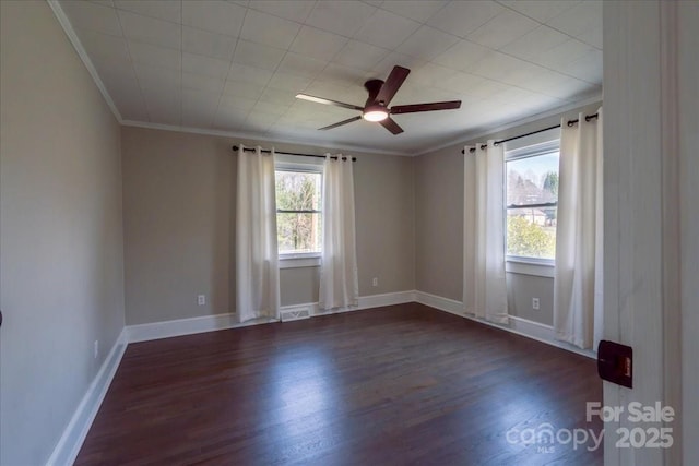 unfurnished room with baseboards, a ceiling fan, crown molding, and dark wood-type flooring