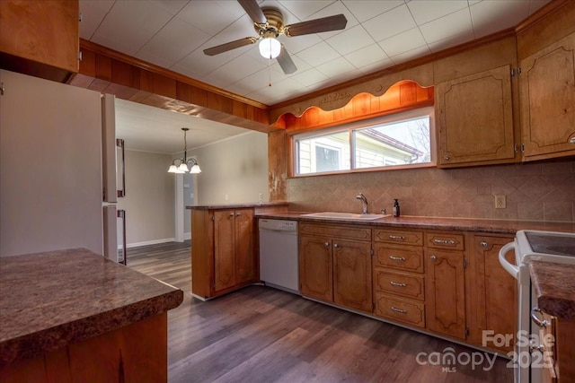 kitchen featuring dark wood finished floors, ornamental molding, white appliances, and a sink