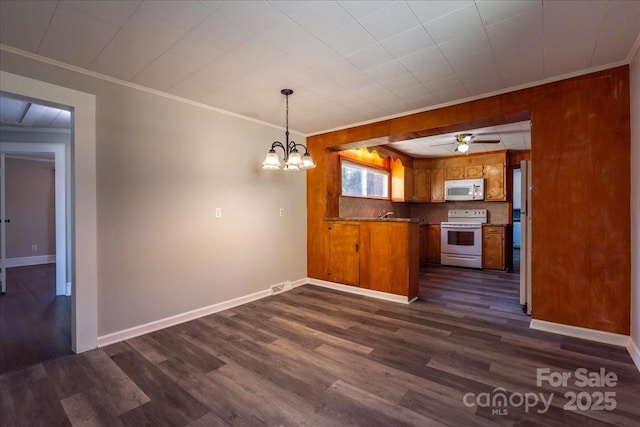kitchen with crown molding, dark wood finished floors, a peninsula, brown cabinetry, and white appliances