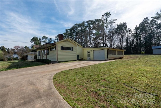 single story home with a chimney, a front lawn, an attached garage, and driveway