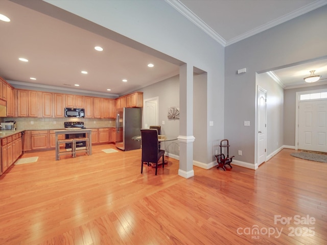 4118 Compostela Ct, Monroe, NC 28110 - kitchen featuring decorative columns, freestanding refrigerator, black microwave, light wood-style floors, and decorative backsplash