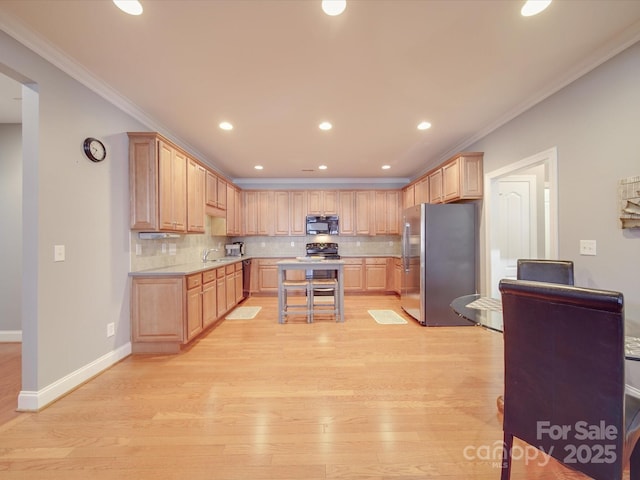 4118 Compostela Ct, Monroe, NC 28110 - kitchen with light countertops, freestanding refrigerator, black microwave, light brown cabinetry, and light wood-type flooring