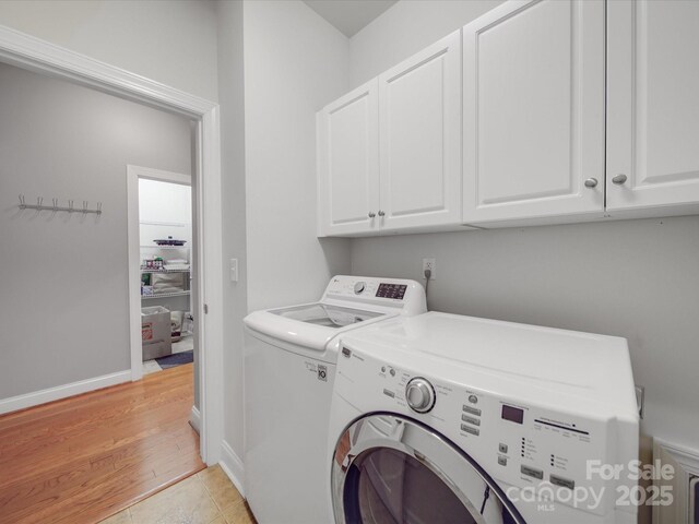4118 Compostela Ct, Monroe, NC 28110 - laundry area featuring independent washer and dryer, light wood-style floors, cabinet space, and baseboards