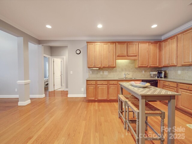 4118 Compostela Ct, Monroe, NC 28110 - kitchen with light wood-type flooring, light countertops, ornamental molding, and tasteful backsplash