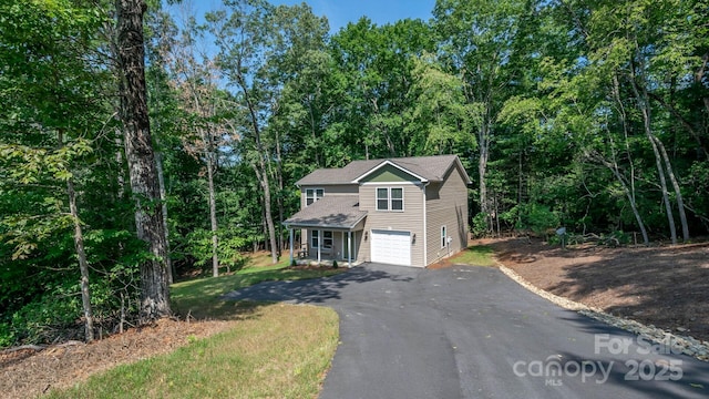 28 Arnie Dr, Etowah, NC 28729 - view of front of home featuring a garage, a wooded view, and driveway