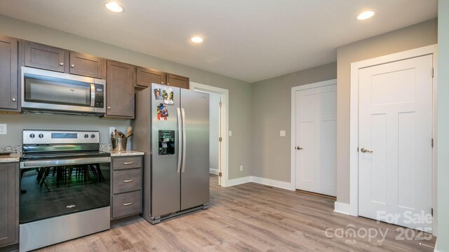 28 Arnie Dr, Etowah, NC 28729 - kitchen featuring baseboards, light stone counters, recessed lighting, light wood-style floors, and stainless steel appliances