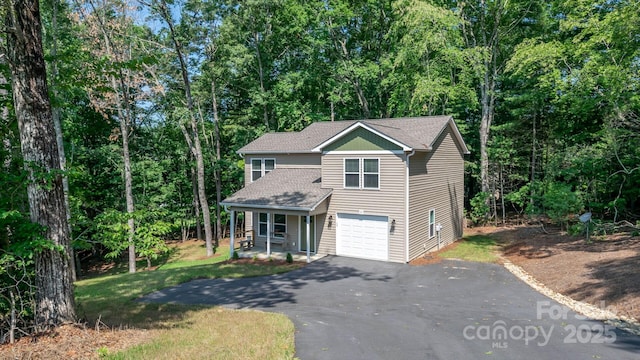 28 Arnie Dr, Etowah, NC 28729 - view of front of house featuring roof with shingles, an attached garage, a front lawn, aphalt driveway, and a view of trees