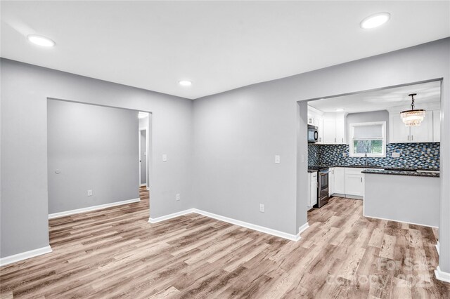 6628 Cool Water Ct, Charlotte, NC 28215 - kitchen featuring light wood-style flooring, white cabinets, dark countertops, stainless steel electric range oven, and recessed lighting