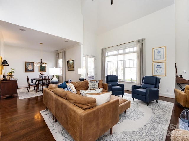 6301 Park Dr S, Charlotte, NC 28210 - living room with dark wood-type flooring, a high ceiling, a chandelier, and baseboards