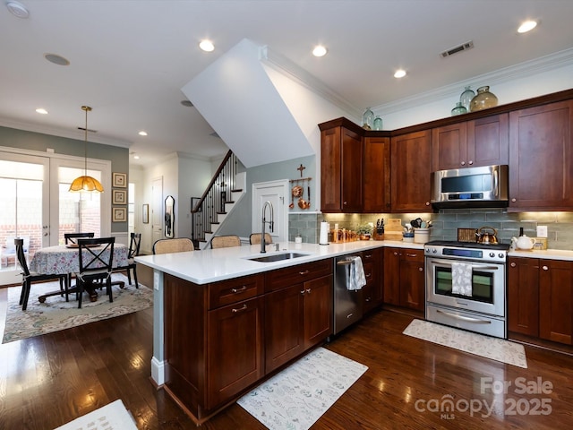 6301 Park Dr S, Charlotte, NC 28210 - kitchen with stainless steel appliances, a sink, a peninsula, light countertops, and crown molding