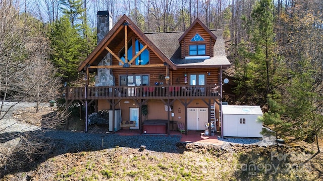133 Saratoga Dr, Bostic, NC 28018 - back of house with a hot tub, a shed, log siding, a chimney, and an outbuilding