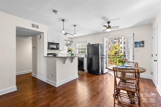 kitchen with black appliances, a ceiling fan, visible vents, and dark wood-type flooring