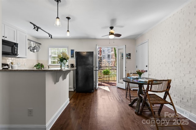dining room featuring brick wall, ceiling fan, dark wood-type flooring, track lighting, and crown molding
