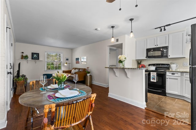 kitchen with tasteful backsplash, black appliances, light stone counters, white cabinetry, and dark wood-style flooring