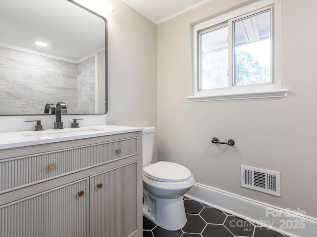 bathroom featuring toilet, vanity, tile patterned flooring, baseboards, and visible vents