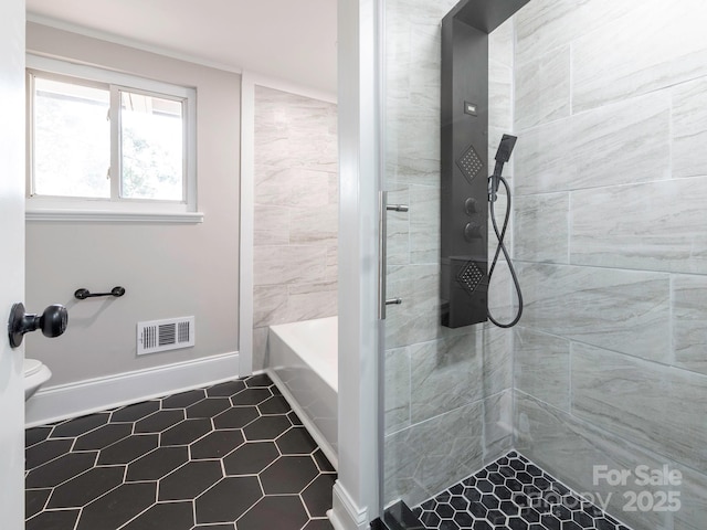 full bath with baseboards, visible vents, a tile shower, and a tub