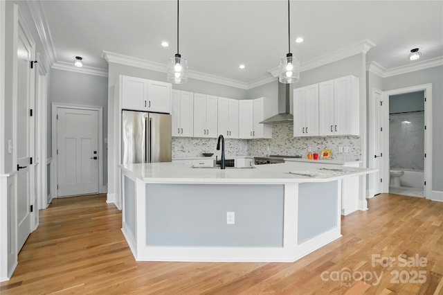 409 Henry Chapel Rd, Belmont, NC 28012 - kitchen with wall chimney range hood, stainless steel refrigerator, light countertops, white cabinetry, and ornamental molding