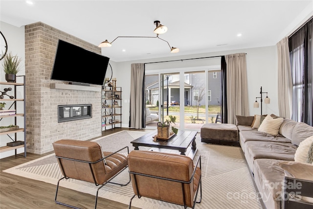 living area with recessed lighting, baseboards, wood finished floors, and a fireplace