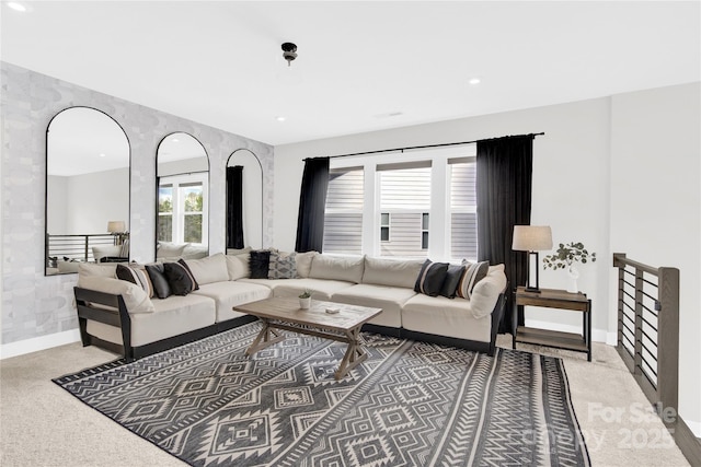 living area featuring baseboards, recessed lighting, and light colored carpet