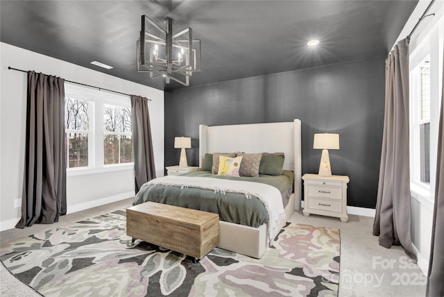 bedroom featuring an inviting chandelier, baseboards, and light colored carpet