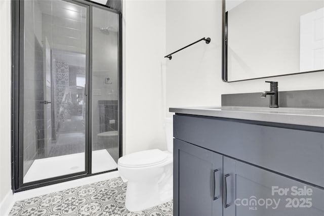 bathroom with vanity, tile patterned floors, a stall shower, and toilet