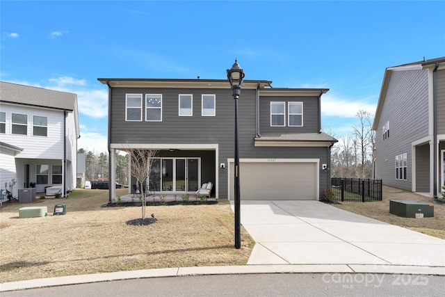 view of front of home with an attached garage, fence, driveway, and cooling unit