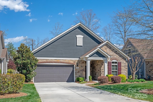 view of front of property with stone siding, an attached garage, a front yard, and driveway