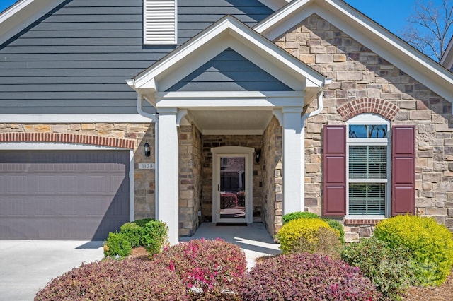 property entrance featuring stone siding and driveway