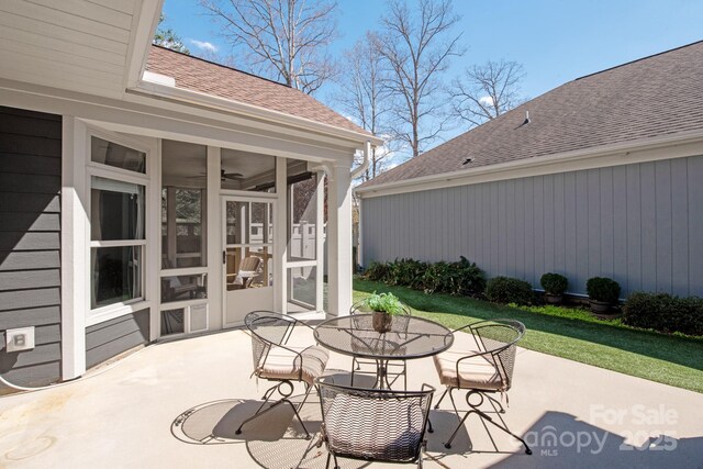 view of patio with outdoor dining space and a sunroom