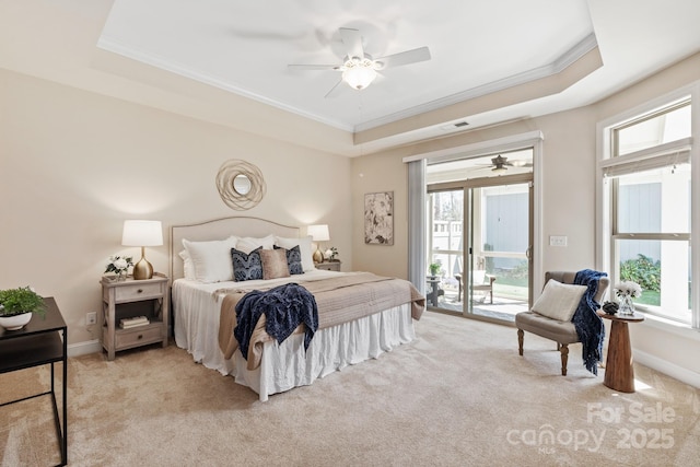 bedroom with multiple windows, a tray ceiling, access to outside, and light colored carpet