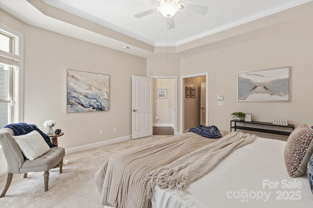 carpeted bedroom featuring baseboards, ornamental molding, and a raised ceiling