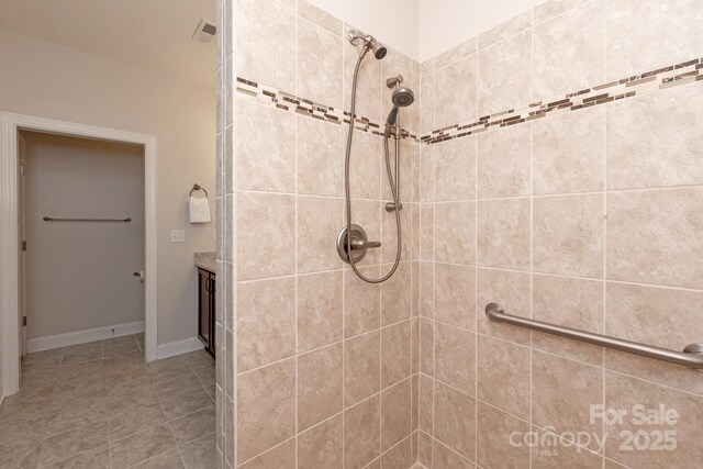 full bathroom featuring vanity, tile patterned floors, and tiled shower