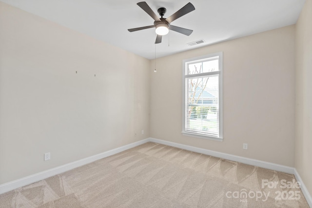 unfurnished room with baseboards, ceiling fan, visible vents, and light carpet