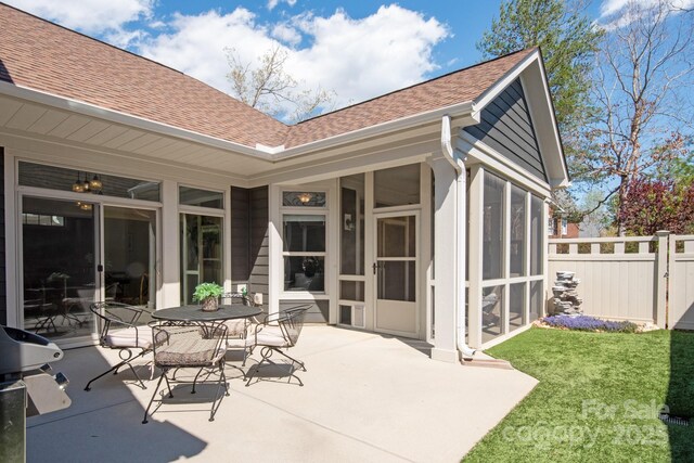 view of patio featuring a sunroom and fence