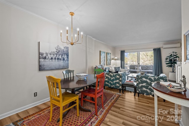 2503 Roswell Ave Unit 208, Charlotte, NC 28209 - dining room with a wall mounted air conditioner, a chandelier, wood finished floors, and crown molding