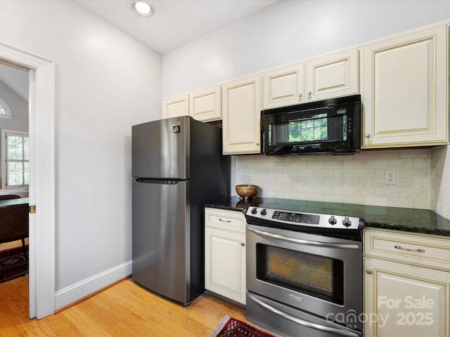 kitchen featuring light wood-type flooring, cream cabinetry, appliances with stainless steel finishes, and decorative backsplash