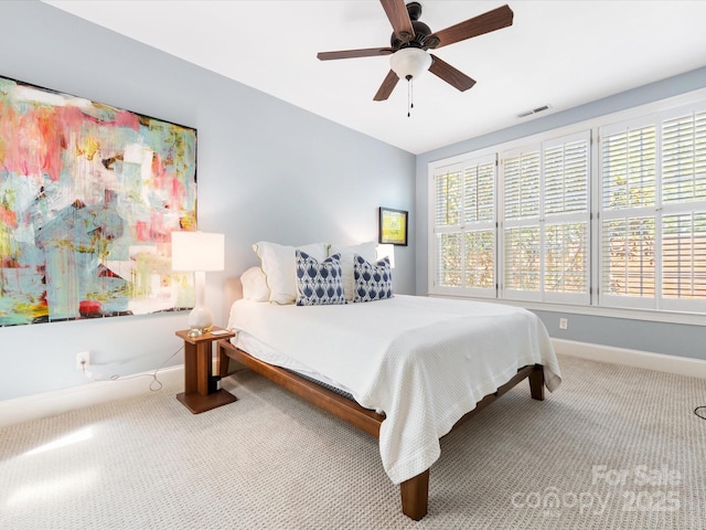 carpeted bedroom featuring multiple windows, visible vents, ceiling fan, and baseboards
