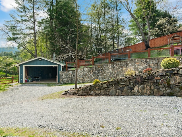 exterior space featuring a garage, fence, and an outdoor structure