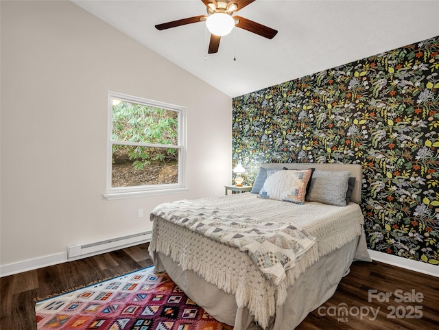 bedroom featuring baseboard heating, wood finished floors, wallpapered walls, and vaulted ceiling