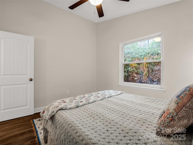bedroom featuring baseboards, ceiling fan, and dark wood-style flooring